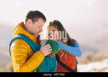 Ein junges Paar und ihr Baby Wandern in den winterlichen Bergen. Stockfoto