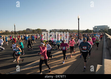 WASHINGTON DC, USA – die Läufer treten beim jährlichen Cherry Blossom Ten Mile Run an, während sie die Arlington Memorial Bridge überqueren und das Lincoln Memorial im Hintergrund sehen. Das Frühlingsrennen, das mit dem National Cherry Blossom Festival zusammenfällt, zieht Tausende von Teilnehmern in die Hauptstadt des Landes. Stockfoto