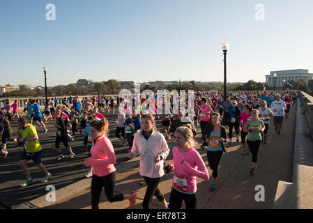 WASHINGTON DC, USA – die Läufer treten beim jährlichen Cherry Blossom Ten Mile Run an, während sie die Arlington Memorial Bridge überqueren und das Lincoln Memorial im Hintergrund sehen. Das Frühlingsrennen, das mit dem National Cherry Blossom Festival zusammenfällt, zieht Tausende von Teilnehmern in die Hauptstadt des Landes. Stockfoto