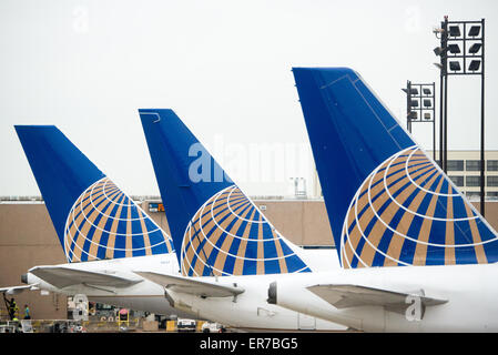 Eine Reihe von drei Schwänzen von United Airlines Flugzeuge aufgereiht am Gate am Flughafen. Jede Rute hat das neue United-Logo nach der Fusion mit Continental Airlines. Stockfoto