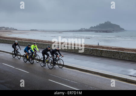 Radfahrer fahren vorbei an St Micheal Mount in Cornwall Stockfoto