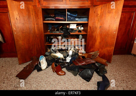 Auswahl an Damenschuhe unordentlich auf Boden vor Kleiderschrank im Schlafzimmer verstreut Stockfoto