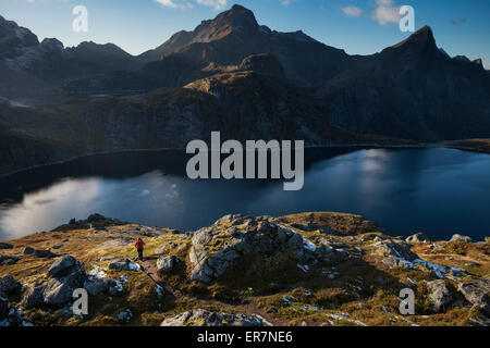 Weibliche Wanderer auf Trail in der Nähe von Munkebu-Hütte mit Hermannsdalstind in den Hintergrund, Moskenesøy, Lofoten Inseln, Norwegen Stockfoto