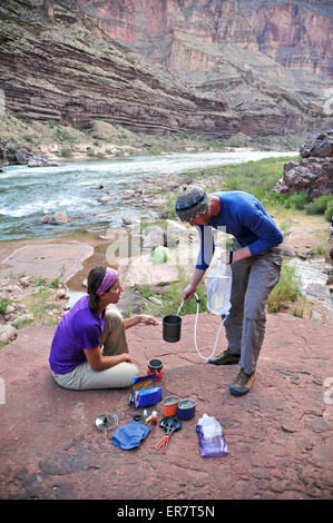 Wanderer kochen Abendessen auf einer Klippe eingeklemmt Terrasse über dem Lager und den Colorado River in der Nähe von Deer Creek Falls im Grand Canyon außerhalb Fredonia, Arizona im November 2011. Stockfoto