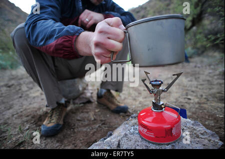 Frau und Mann Rucksacktouristen Vorbereitung Abendessen mit einem Campingkocher im Camp in der Nähe Charleboise Quellen in La Barge Canyon auf den Holländers Weg im Wildnisgebiet Aberglaube, Tonto National Forest in der Nähe von Phoenix, Arizona November 2011. Stockfoto