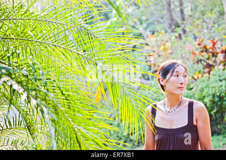 Schöne Frau in braunen Kleid im Palm tree Stockfoto