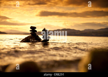 Zwei kleine Felsen Stapel im Wasser bei Sonnenuntergang. Stockfoto