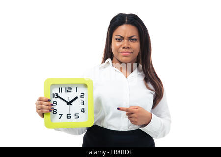 Unzufrieden Afro amerikanische Geschäftsfrau Zeigefinger auf der Uhr, die isoliert auf einem weißen Hintergrund. Blick in die Kamera Stockfoto