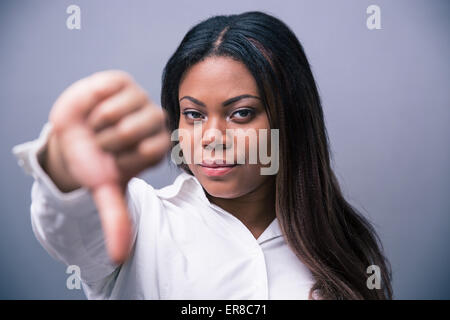 Afrikanische Geschäftsfrau Showung Daumen nach unten über den grauen Hintergrund Stockfoto