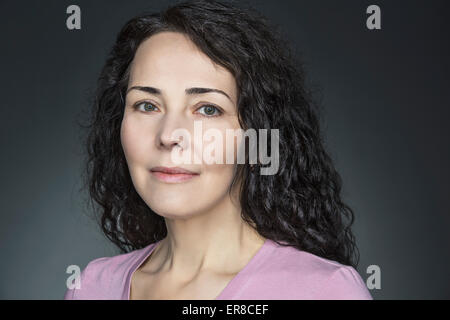 Close-up Portrait der selbstbewusste Reife Frau über grauen Hintergrund Stockfoto