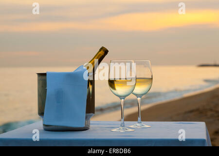Ein Tisch im Restaurant am Strand bei Sonnenuntergang. Stockfoto