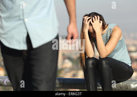 Trennung eines Paares mit Bösewicht und traurige Freundin mit einer Stadt im Hintergrund Stockfoto