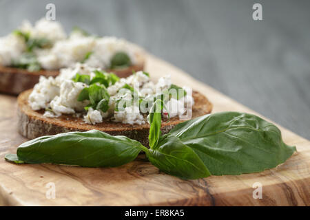 Roggen-Sandwich oder Bruschetta mit Ricotta, Kräutern und Basilikum Stockfoto