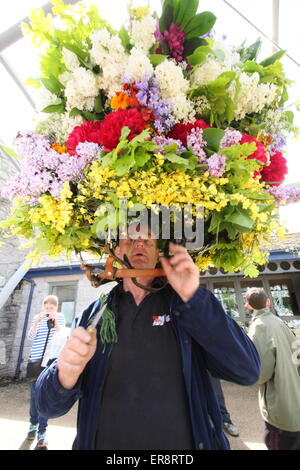 Eine Girlande Maker macht den letzten Schliff mit einer floralen Kopfschmuck aus zur Feier des Oak Apple Day, Castleton, Derbyshire, UK Stockfoto