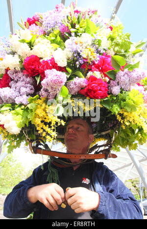 Eine Girlande Maker macht den letzten Schliff mit einer floralen Kopfschmuck aus zur Feier des Oak Apple Day, Castleton, Derbyshire, UK Stockfoto