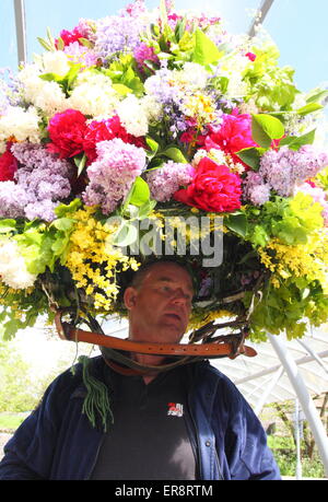 Eine Girlande Maker macht den letzten Schliff mit einer floralen Kopfschmuck aus zur Feier des Oak Apple Day, Castleton, Derbyshire, UK Stockfoto