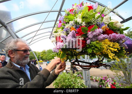 Eine Girlande Maker macht den letzten Schliff mit einer floralen Kopfschmuck aus zur Feier des Oak Apple Day, Castleton, Derbyshire, UK Stockfoto