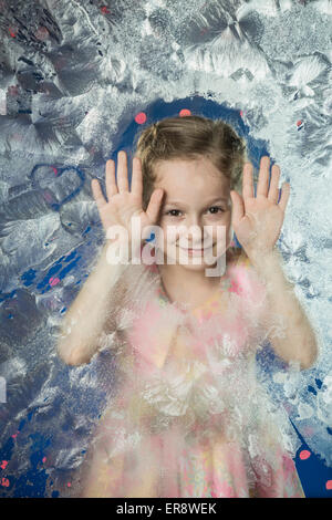 Porträt von netten Mädchen stützte sich auf gefrorenem Glas Stockfoto