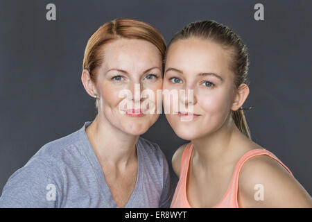 Porträt des Lächelns, Mutter und Tochter vor grauem Hintergrund Stockfoto