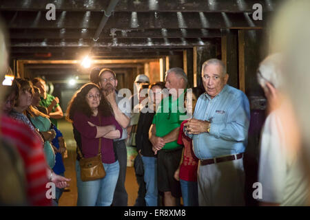 Frankfort, Kentucky - Reiseleiter (blaues Hemd) führt Touristen durch eine alternde Lager auf die Buffalo Trace Distillery. Stockfoto