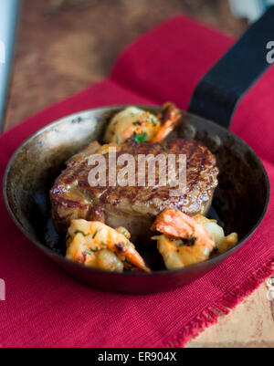 Steak mit ganzen Garnelen in einer Pfanne Stockfoto