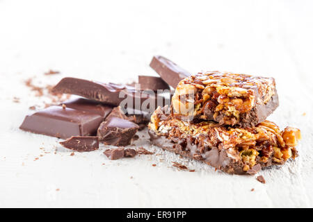 Müsliriegel mit Schokolade auf weißem Holz Hintergrund Stockfoto