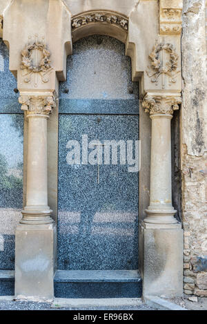 Aus Marmor Grab geschmückt mit Säulen und ein Kreuz auf einem Friedhof. Stockfoto