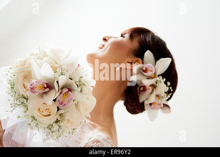 Braut posiert mit ihrem Bouquet nach dem Aufstehen Profi machen für ihren Hochzeitstag. Braut hat Pony. Stockfoto