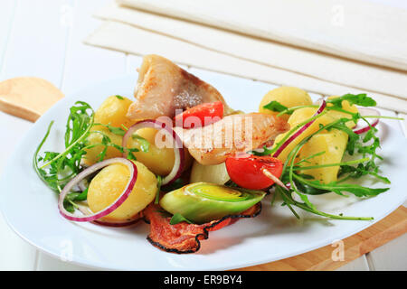 Fisch-Spieß und Kartoffeln mit Lauch und Rucola Stockfoto