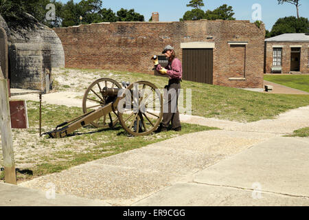 Mann im Bürgerkrieg Gewand zeigt laden und Abfeuern einer Vintage Kanone im Fort Gaines. Stockfoto