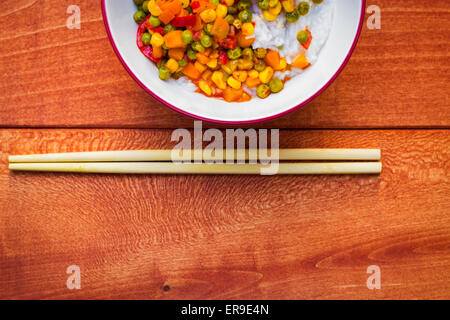 Schüssel mit asiatischen Klebreis mit Gemüsesauce Stockfoto