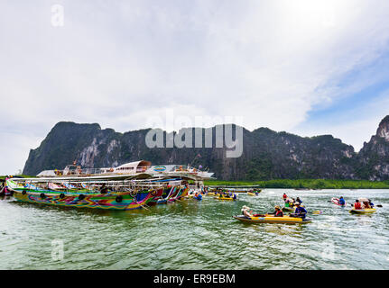 PHANG NGA, THAILAND - 27. April 2015: Touristen freuen sich über das Kanufahren in der Nähe von Insel und große Schiffe auf dem Meer Oberfläche mit einer Stockfoto