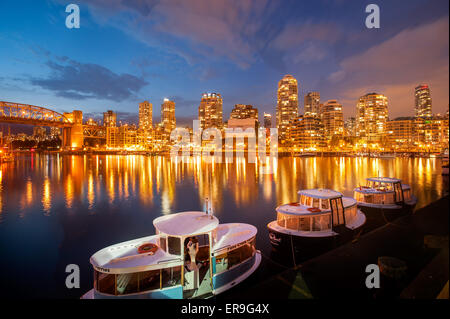 Skyline von Vancouver Yaletown und False Creek in der Dämmerung, von Granville Island aus gesehen.  Vancouver-Fähren bei Sonnenuntergang Stockfoto