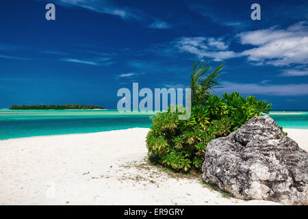 Verträumte kristallklaren Meer mit einem Stein auf den weißen Sandstrand Stockfoto