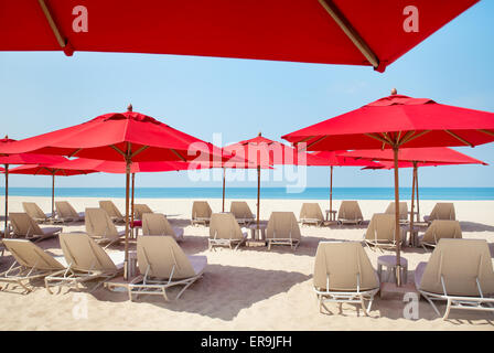 Liegestühle und Sonnenschirme am Sandstrand Stockfoto