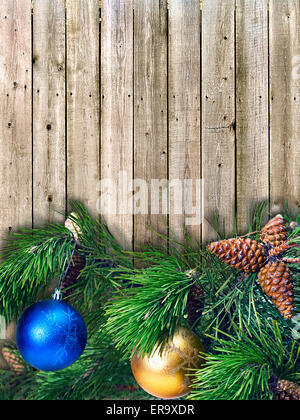 Christmas Pine Zweige mit farbigen Kugeln auf dem Hintergrund der Holzbretter Stockfoto