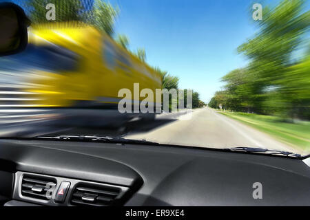 Auf die Geschwindigkeit der Bewegung der LKW auf der Straße aus dem Fenster eines entgegenkommenden Autos verschwommen Stockfoto