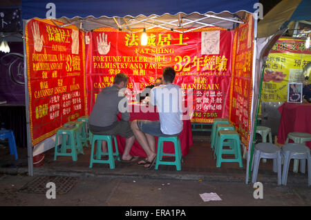 Dh Temple Street Market Yau MA Tei HONG KONG westlichen Touristen mit wahrsagerin Stall chinesischen sagen Stockfoto