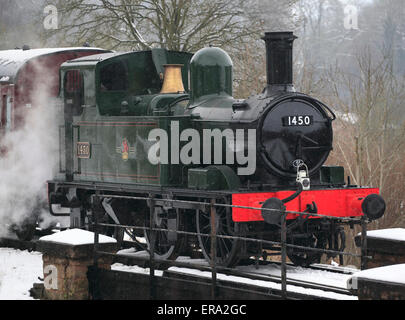 Einer der kleineren Lokomotiven Großbritanniens, No.1450 0-4-2 Tank Motor wartet nur außerhalb einer verschneiten Highley Stockfoto