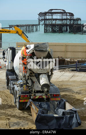 Auf der Baustelle des Brighton BA i360, ein Mann reinigt Betonmischer LKW, bevor Sie die Website verlässt eine andere Last zu sammeln. Der Beton wird aus dem Keller und Fundamente für die i360's Tower. Während des Prozesses um 2.640 Tonnen Beton wurde auf die Website von Lkw angeliefert. Der marode West Pier im Hintergrund gesehen werden kann. Stockfoto