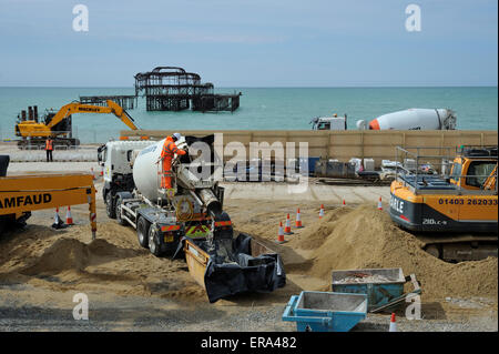 Auf der Baustelle des Brighton BA i360, ein Mann reinigt Betonmischer LKW, bevor Sie die Website verlässt eine andere Last zu sammeln. Der Beton wird aus dem Keller und Fundamente für die i360's Tower. Während des Prozesses um 2.640 Tonnen Beton wurde auf die Website von Lkw angeliefert. Der marode West Pier im Hintergrund gesehen werden kann. Stockfoto