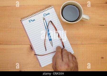 Auflistung der vor- und Nachteile auf einen Spiral-Notizblock. Stockfoto