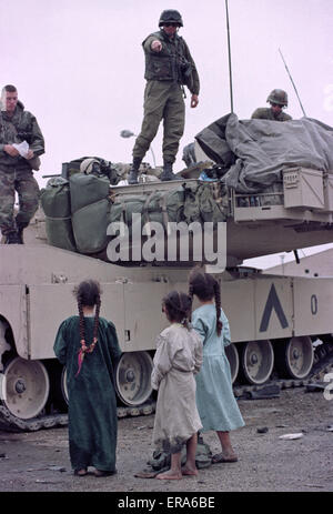 März 1991 schiitische irakische Kinder stehen neben einem Abrams-Panzer der US-Armee in einem Lager in der Nähe von Safwan im südlichen Irak nahe der Grenze zu Kuwait.