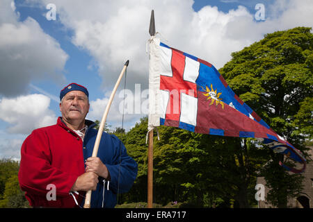 Archer mit heraldischer Gefechtsflagge in Hoghton, Lancashire, Großbritannien. Mai 2015. Mick Weaver, Bogenschütze bei der Nachstellung des Rosenkriegs von Sir John Saviles Household und der Gruppe aus dem 15. Jahrhundert. Hoghton Tower Preston verwandelte sich mit lebendigen Geschichtsausstellungen von Handwerkern, Soldaten und dem Alltag aus der Zeit von Elizabeth Woodville (die Weiße Königin) und Richard III Bekannt als Cousins-Krieg oder Krieg der Rosen war der dynastische Kampf zwischen den königlichen Haushalten von York und Lancaster, die jedes ihr Recht beanspruchten, über ihre Verbindungen zum angepeitschten Edward III. Zu herrschen Stockfoto