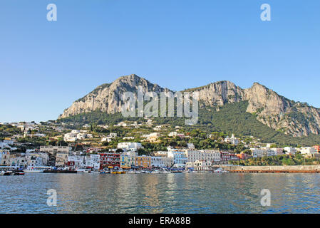 Boote und Gebäude der Marina Grande auf der Insel Capri, Italien, mit Bergen im Hintergrund Stockfoto