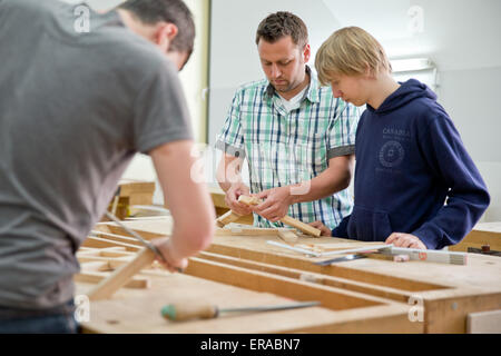 Würzburg, Deutschland. 18. Mai 2015. Tischlermeister und Lehrer Florian Schöpf (L) anweist Schüler David, die im Jahr der Berufsvorbereitung in der Tischlerei des Don-Bosco-Berufsschule (Don-Bosco-Berufsschule) in Würzburg, Deutschland, 18. Mai 2015 ist. Der Berufsschule für Schülerinnen und Schüler mit sonderpädagogischem Förderbedarf ist der einzige in Bayern, nominiert für den Schulpreis (lit.) Auszeichnung der Schule) 2015. Foto: Daniel Karmann/Dpa/Alamy Live News Stockfoto