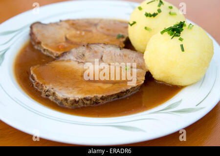 Teller mit Schweinebraten, Knödel und Soße Stockfoto