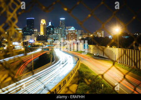 Maschendrahtzaun und Blick auf i-35 und die Skyline bei Nacht, gesehen von der 24th Street Fußgängerbrücke in Minneapolis, Minneso Stockfoto