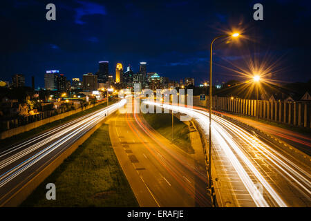 I-35 und die Skyline bei Nacht, gesehen von der 24. Straße Fußgänger-Brücke in Minneapolis, Minnesota. Stockfoto