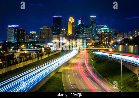 I-35 und die Skyline bei Nacht, gesehen von der 24. Straße Fußgänger-Brücke in Minneapolis, Minnesota. Stockfoto